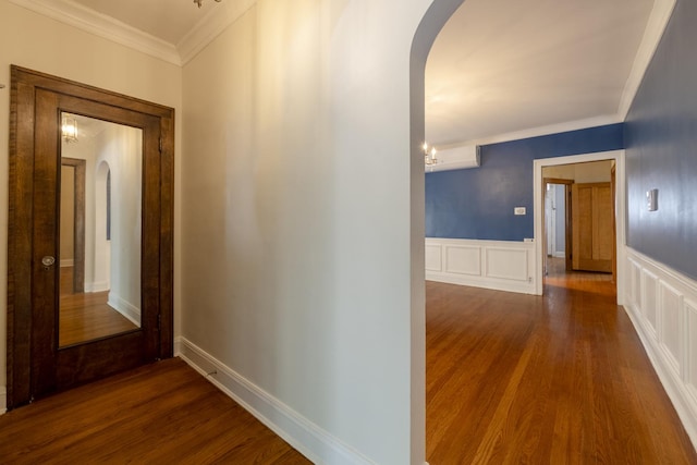 6712 N Maplewood Ave, Chicago, IL 60645 - hall with arched walkways, crown molding, dark wood-style flooring, a decorative wall, and wainscoting