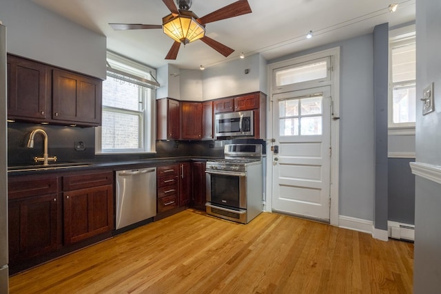 6712 N Maplewood Ave, Chicago, IL 60645 - kitchen with appliances with stainless steel finishes, baseboard heating, dark countertops, ceiling fan, and plenty of natural light
