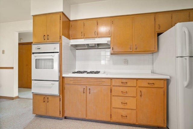 200 S Madison St, Towanda, IL 61776 - kitchen with white appliances, a warming drawer, under cabinet range hood, light countertops, and decorative backsplash