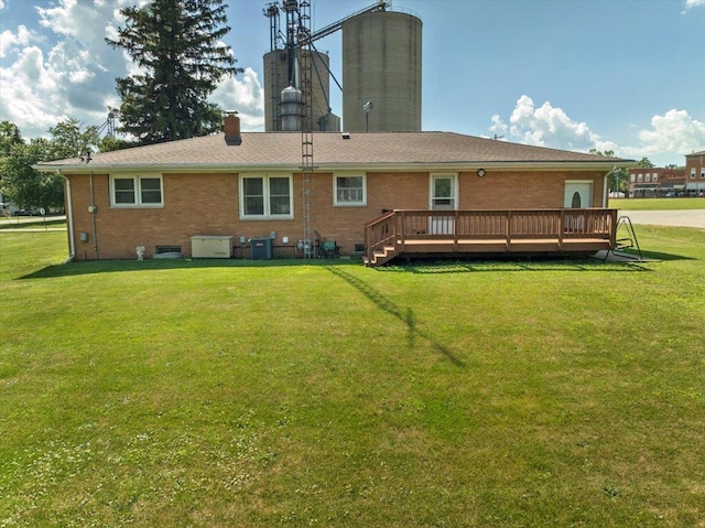 200 S Madison St, Towanda, IL 61776 - rear view of house with brick siding, a chimney, a deck, and a lawn