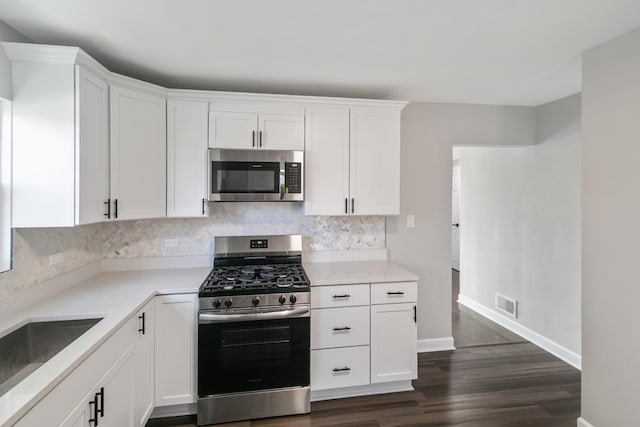 2263 S 14th Ave, North Riverside, IL 60546 - kitchen with stainless steel appliances, backsplash, white cabinetry, and dark wood-style flooring