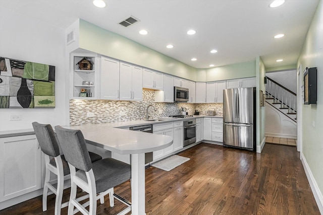 718 S Washington Ave, Park Ridge, IL 60068 - kitchen featuring stainless steel appliances, light countertops, a peninsula, decorative backsplash, and dark wood finished floors
