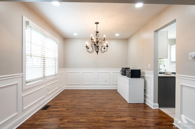 8619 Koehler Dr, Tinley Park, IL 60487 - unfurnished dining area with a chandelier, dark wood-type flooring, wainscoting, recessed lighting, and a decorative wall