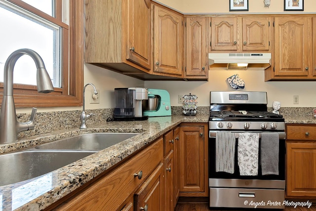 3406 W Bretons Dr, Mchenry, IL 60050 - kitchen featuring stainless steel range with gas cooktop, under cabinet range hood, brown cabinets, and light stone countertops
