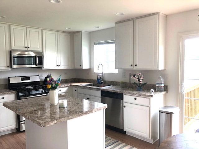 900 Heartland Park Ln, Antioch, IL 60002 - kitchen with appliances with stainless steel finishes, wood finished floors, white cabinets, and recessed lighting