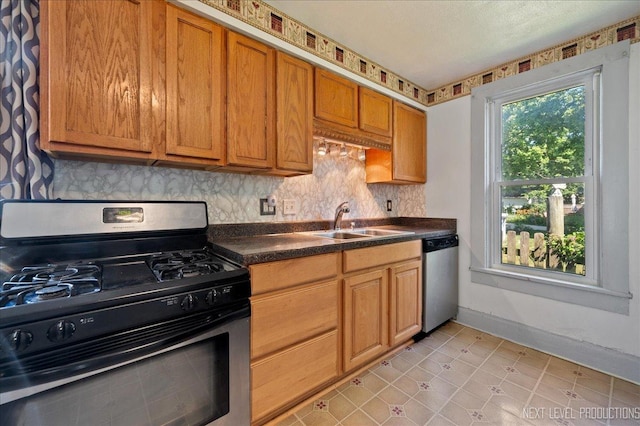 12 N Lincolnway Ave, North Aurora, IL 60542 - kitchen featuring gas stove, stainless steel dishwasher, dark countertops, decorative backsplash, and brown cabinetry