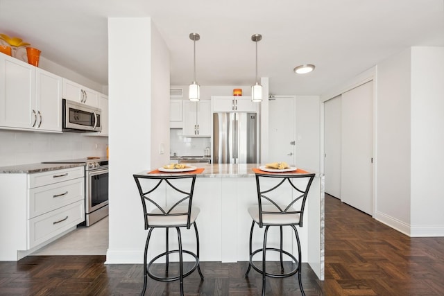 601 E 32nd St Unit 1002, Chicago, IL 60616 - kitchen with stainless steel appliances, backsplash, a breakfast bar area, and white cabinets