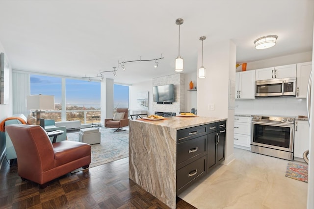 601 E 32nd St Unit 1002, Chicago, IL 60616 - kitchen with appliances with stainless steel finishes, open floor plan, white cabinets, tasteful backsplash, and light stone counters
