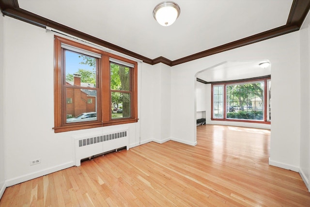 3901 N Neva Ave, Chicago, IL 60634 - unfurnished room featuring radiator, wood-type flooring, plenty of natural light, arched walkways, and ornamental molding