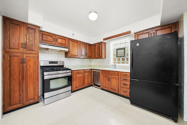 3901 N Neva Ave, Chicago, IL 60634 - kitchen featuring appliances with stainless steel finishes, under cabinet range hood, light countertops, brown cabinets, and tasteful backsplash