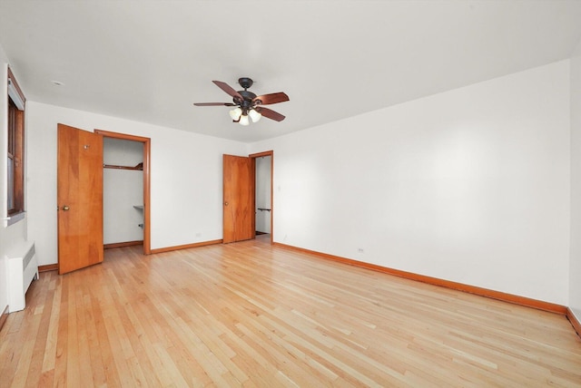 3901 N Neva Ave, Chicago, IL 60634 - unfurnished bedroom featuring light wood finished floors, ceiling fan, a closet, a walk in closet, and radiator heating unit