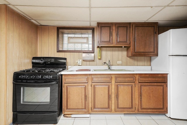 3901 N Neva Ave, Chicago, IL 60634 - kitchen with black gas range oven, freestanding refrigerator, light countertops, wooden walls, and brown cabinets
