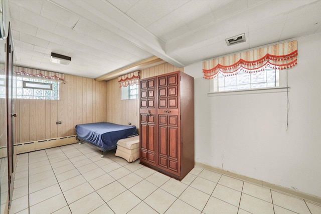 3901 N Neva Ave, Chicago, IL 60634 - bedroom with multiple windows, wooden walls, baseboard heating, and light tile patterned floors