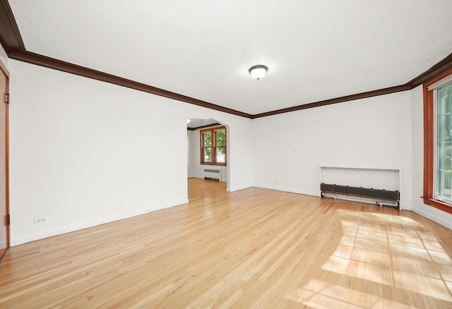 3901 N Neva Ave, Chicago, IL 60634 - unfurnished living room with arched walkways, crown molding, light wood-type flooring, and radiator