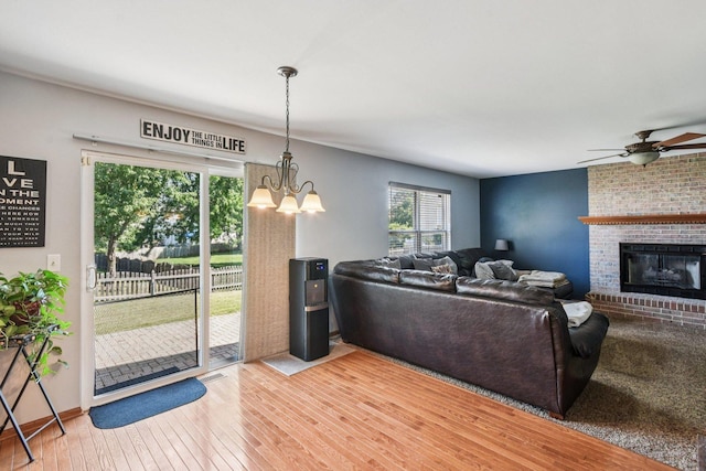 5509 Hickory Grove Ct, Plainfield, IL 60586 - living area featuring hardwood / wood-style floors, a ceiling fan, a chandelier, and a brick fireplace