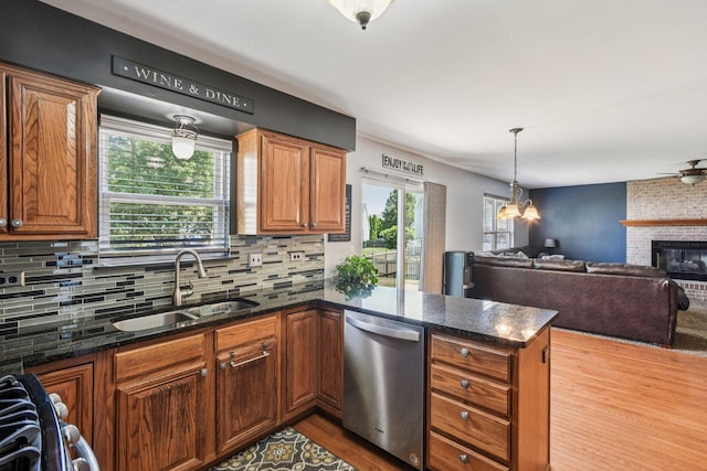 5509 Hickory Grove Ct, Plainfield, IL 60586 - kitchen with stainless steel dishwasher, a peninsula, wood finished floors, a fireplace, and decorative backsplash