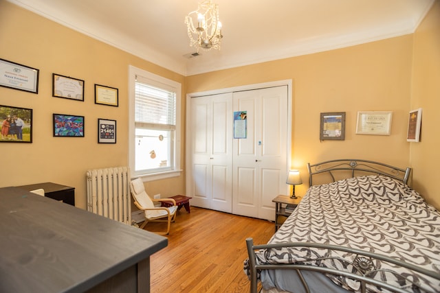 2815 W Fitch Ave, Chicago, IL 60645 - bedroom featuring radiator heating unit, a chandelier, light wood-style flooring, a closet, and crown molding