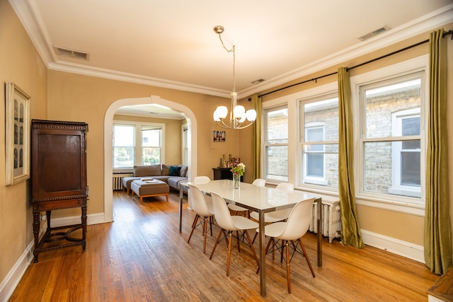 2815 W Fitch Ave, Chicago, IL 60645 - dining space featuring arched walkways, a chandelier, wood finished floors, and ornamental molding