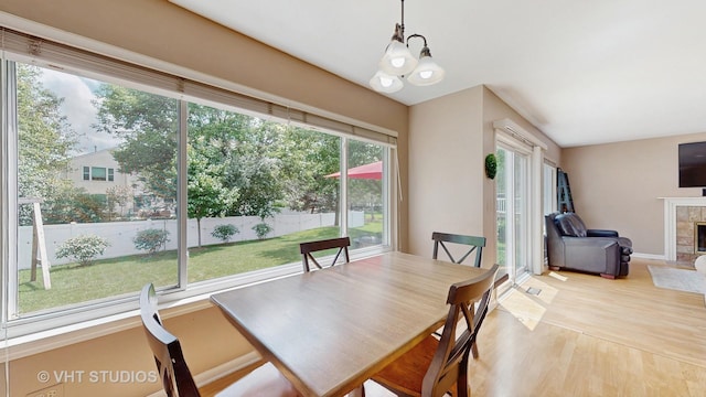 654 Linden Dr, Carol Stream, IL 60188 - dining area featuring wood finished floors, a tiled fireplace, and a chandelier