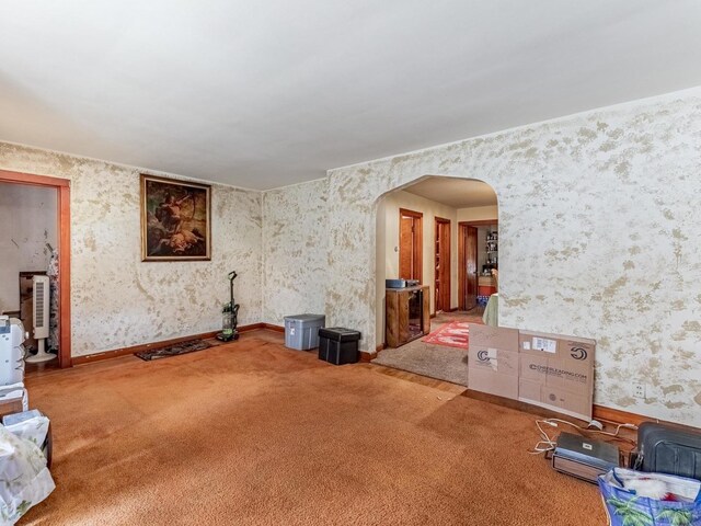 7959 S Coles Ave, Chicago, IL 60617 - unfurnished living room with arched walkways, wallpapered walls, and carpet