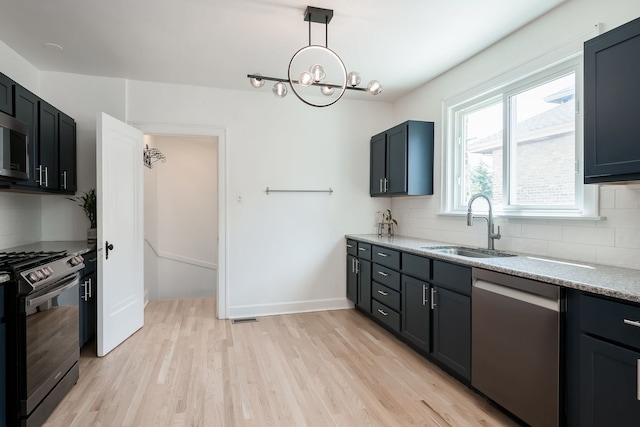 1833 Cuyler Ave, Berwyn, IL 60402 - kitchen featuring stainless steel appliances, decorative backsplash, light wood-style flooring, and a chandelier