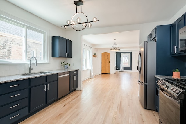 1833 Cuyler Ave, Berwyn, IL 60402 - kitchen featuring appliances with stainless steel finishes, light wood-type flooring, tasteful backsplash, pendant lighting, and a chandelier