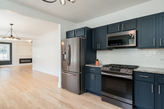 1833 Cuyler Ave, Berwyn, IL 60402 - kitchen with appliances with stainless steel finishes, light wood finished floors, tasteful backsplash, and light stone counters