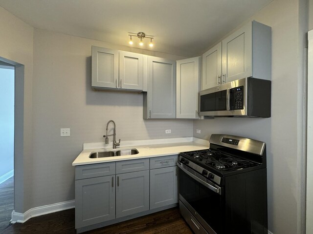 11022 S Vernon Ave, Chicago, IL 60628 - kitchen featuring stainless steel appliances, dark wood finished floors, gray cabinets, and light countertops