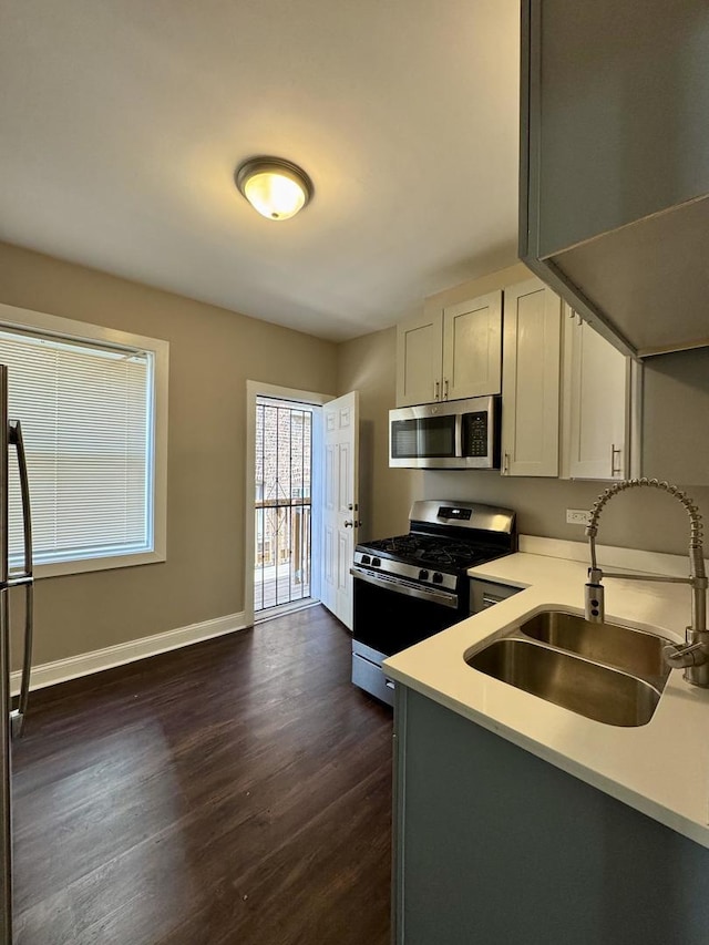 11022 S Vernon Ave, Chicago, IL 60628 - kitchen featuring appliances with stainless steel finishes, dark wood finished floors, and light countertops