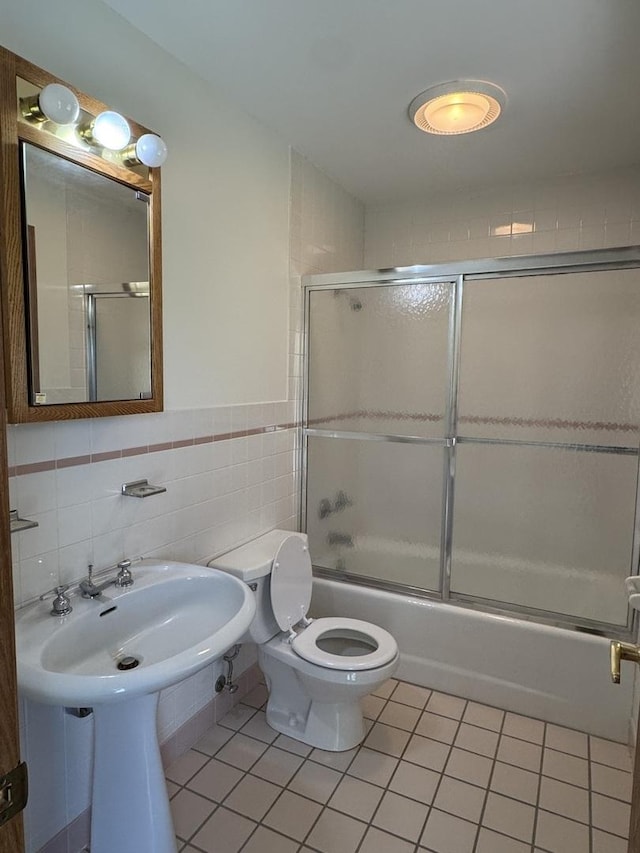 532 E 2nd St, Herscher, IL 60941 - full bathroom with tile patterned floors, bath / shower combo with glass door, tile walls, and a wainscoted wall