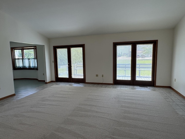 532 E 2nd St, Herscher, IL 60941 - empty room with french doors, light carpet, vaulted ceiling, and light tile patterned floors