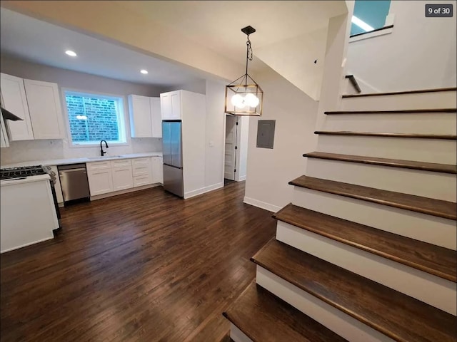1634 W 38th St, Chicago, IL 60609 - kitchen featuring appliances with stainless steel finishes, white cabinets, light countertops, dark wood-style floors, and electric panel