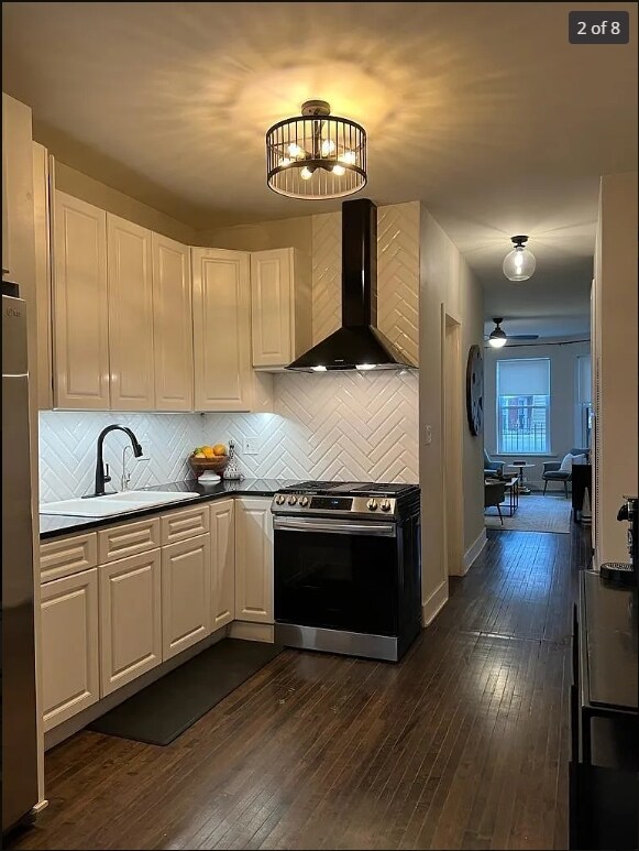 1634 W 38th St, Chicago, IL 60609 - kitchen with stainless steel range oven, wall chimney exhaust hood, tasteful backsplash, and dark wood-style floors