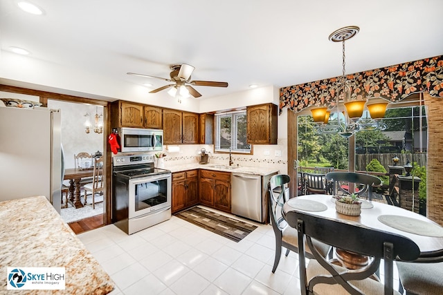 14463 S Canvasback Ct, Homer Glen, IL 60491 - kitchen with stainless steel appliances, light countertops, ceiling fan, hanging light fixtures, and a chandelier