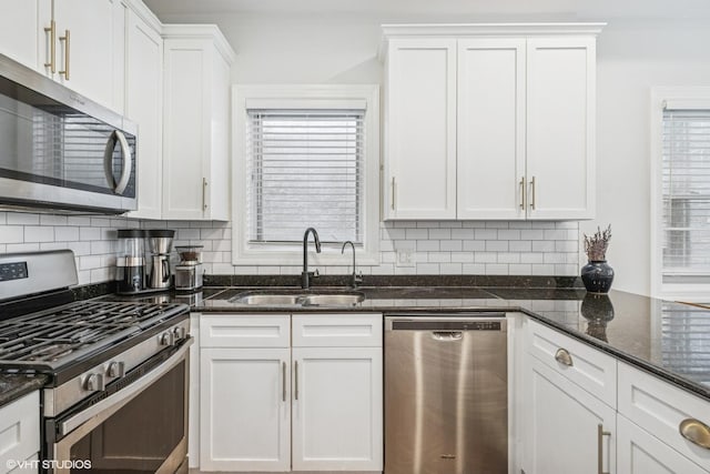 2930 N Damen Ave Unit 2, Chicago, IL 60618 - kitchen featuring appliances with stainless steel finishes, white cabinets, backsplash, and dark stone countertops
