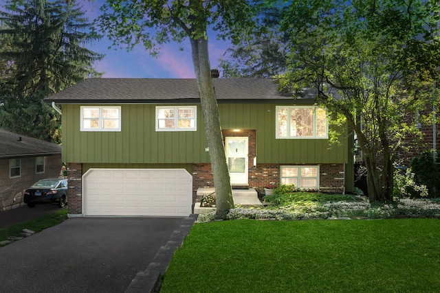 5245 Fairmount Ave, Downers Grove, IL 60515 - raised ranch featuring brick siding, an attached garage, driveway, a front lawn, and roof with shingles