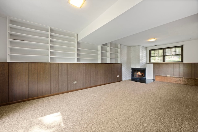5245 Fairmount Ave, Downers Grove, IL 60515 - unfurnished living room with wood walls, a brick fireplace, built in shelves, carpet floors, and wainscoting
