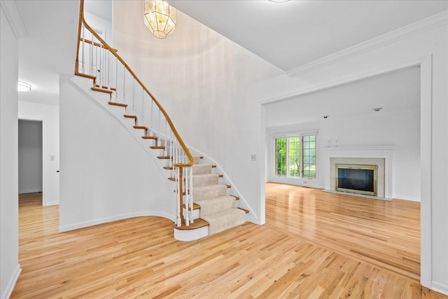1280 Lawrence Ave, Lake Forest, IL 60045 - stairway featuring wood finished floors, a fireplace with flush hearth, and ornamental molding
