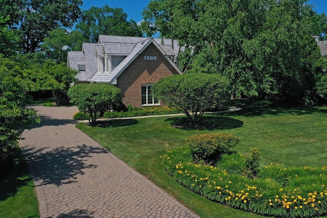 1280 Lawrence Ave, Lake Forest, IL 60045 - tudor house featuring a front lawn, brick siding, and decorative driveway
