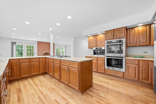 1280 Lawrence Ave, Lake Forest, IL 60045 - kitchen featuring stainless steel double oven, light wood-style floors, gas cooktop, recessed lighting, and light countertops