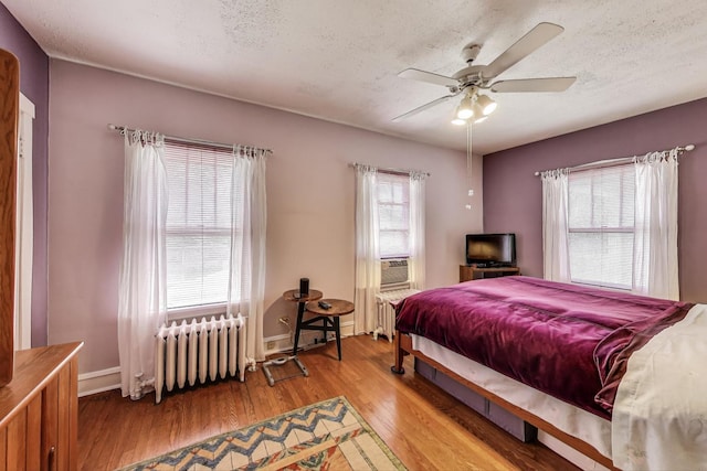 1003 Mapleton Ave, Oak Park, IL 60302 - bedroom featuring radiator heating unit, wood finished floors, a textured ceiling, ceiling fan, and cooling unit