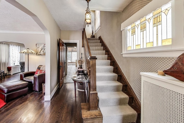 1003 Mapleton Ave, Oak Park, IL 60302 - stairs featuring arched walkways, wallpapered walls, wood-type flooring, healthy amount of natural light, and a textured ceiling