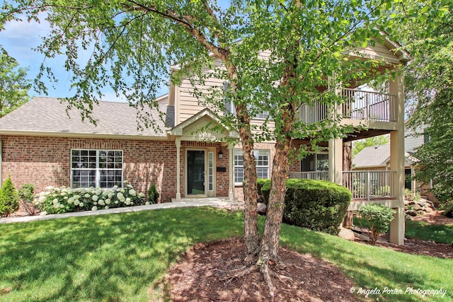 312 Whitaker Trl Unit 312, Mchenry, IL 60050 - view of front of property with brick siding, a front lawn, a shingled roof, and a balcony