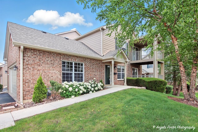 312 Whitaker Trl Unit 312, Mchenry, IL 60050 - view of front of house featuring a balcony, brick siding, a front yard, roof with shingles, and a garage