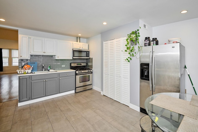 1931 N Leamington Ave, Chicago, IL 60639 - kitchen featuring appliances with stainless steel finishes, gray cabinets, light countertops, recessed lighting, and backsplash
