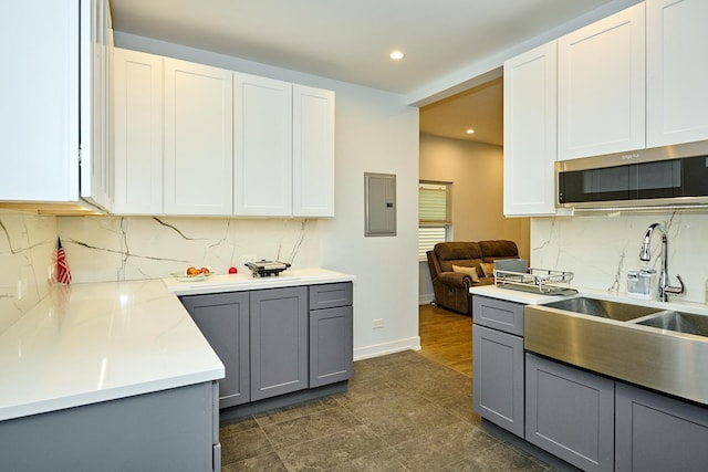 1931 N Leamington Ave, Chicago, IL 60639 - kitchen featuring gray cabinets, electric panel, stainless steel microwave, backsplash, and recessed lighting