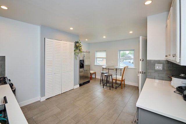 1931 N Leamington Ave, Chicago, IL 60639 - kitchen with stainless steel fridge, recessed lighting, backsplash, white cabinets, and light wood-type flooring