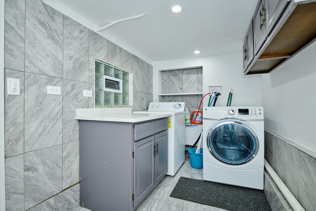 1931 N Leamington Ave, Chicago, IL 60639 - laundry room featuring washer and dryer, tile walls, cabinet space, light marble finish floors, and recessed lighting