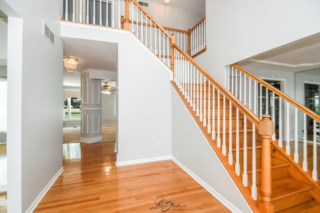 15516 Frontage Rd, Markham, IL 60428 - stairs featuring a high ceiling, wood finished floors, ceiling fan, and decorative columns