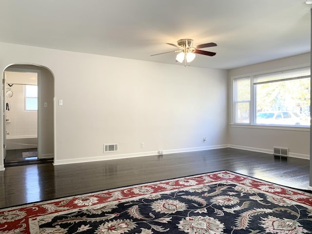 652 Beckman Dr, Kankakee, IL 60901 - empty room with arched walkways, ceiling fan, plenty of natural light, and dark wood-style floors